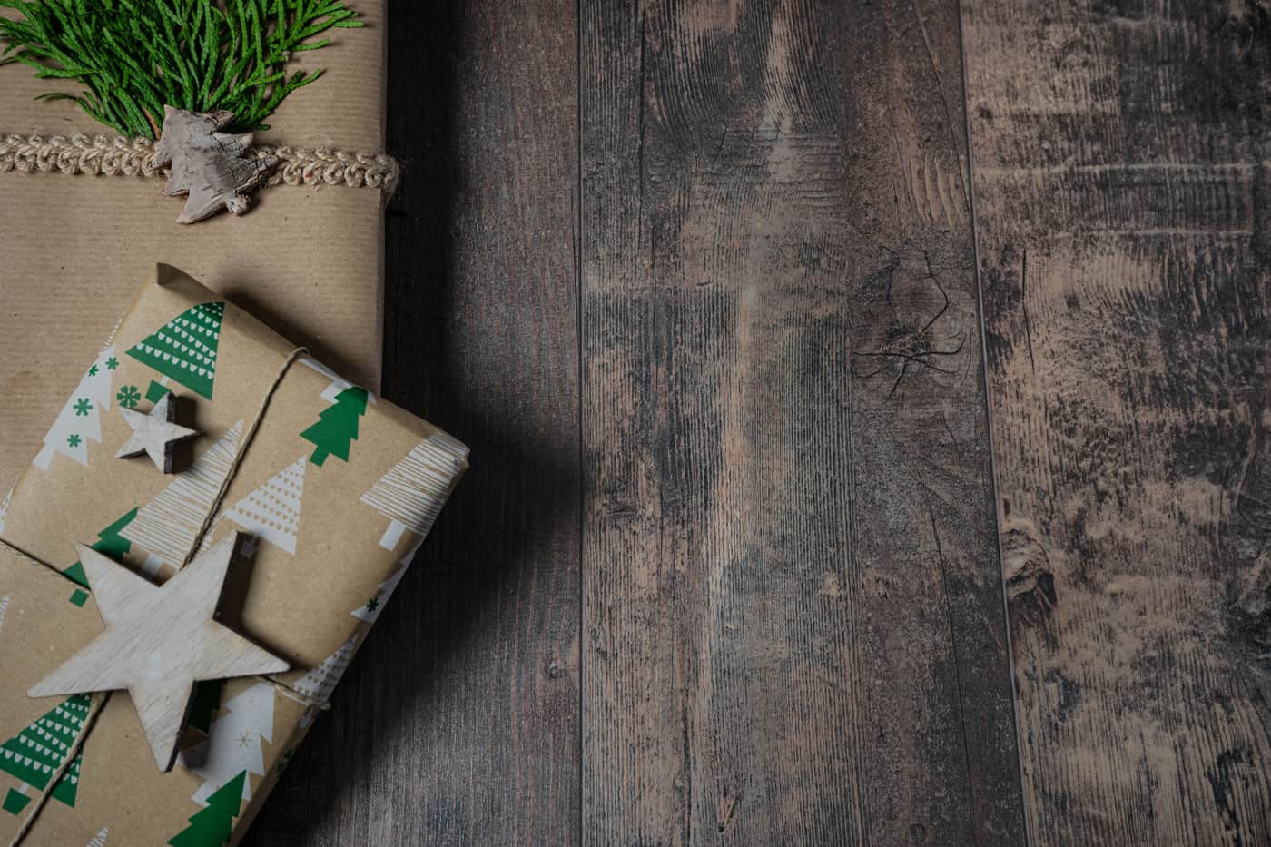 Gifts wrapped in brown paper on a wooden surface